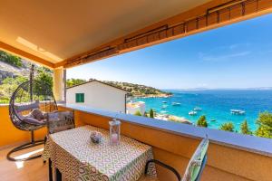 a table on a balcony with a view of the ocean at Apartment Smokvina in Punat
