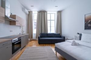 a kitchen and a living room with a couch and a couch at Cosy Apartment Naschmarkt I new furnished in Vienna