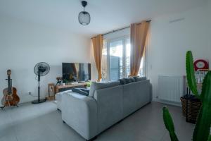 - un salon avec un canapé et une grande fenêtre dans l'établissement T2 cosy Bordeaux - tram & parking, à Cenon