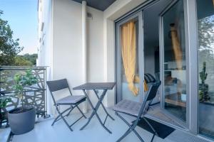 d'un balcon avec des chaises et une table. dans l'établissement T2 cosy Bordeaux - tram & parking, à Cenon