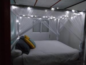 uma cama numa tenda com luzes em Ti kaz anturium em La Possession