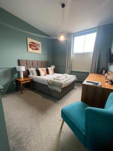 Rickinghall的住宿－The Bell Inn, Rickinghall，一间卧室配有一张床、一张沙发和一把椅子
