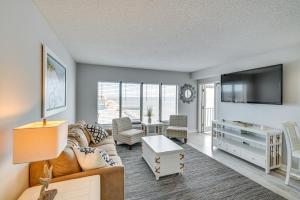 uma sala de estar com um sofá e uma televisão em Oceanfront Myrtle Beach Condo with Balcony and Views! em Myrtle Beach