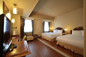 高雄的住宿－歌德商旅，酒店客房设有两张床和一台平面电视。