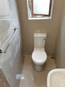 a small bathroom with a toilet and a sink at Dreamers nest in Richards Bay