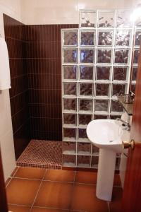 uma casa de banho com um lavatório e um chuveiro em Hostal Andalucía em Chipiona