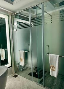 uma casa de banho com uma cabina de duche em vidro e toalhas em Fleet Club Mahrousa em Alexandria