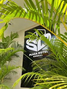 um sinal para um hotel paxa numa parede com plantas em SD Plaza Hotel em Sobral