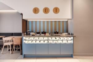 Una panadería con un mostrador con donuts. en B&B HOTEL Lille Lillenium Eurasanté en Lille