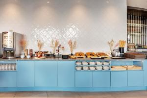 a kitchen with a blue counter with food on it at B&B HOTEL Lille Lillenium Eurasanté in Lille