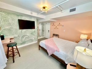 um quarto com uma cama e uma televisão na parede em Peninsula Bed & Cocktails em St. Petersburg