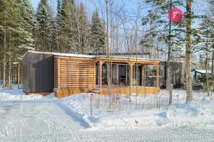 uma cabana de madeira na floresta na neve em The HALO / SPA Sauna Pool Billiards Hiking / 25 min from Quebec em Pont-Rouge