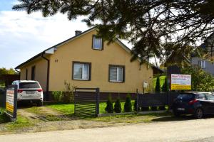 a house with cars parked in front of it at Chata pod wyciągiem in Wańkowa