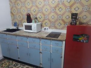 a kitchen with a counter with a microwave and a refrigerator at La gota de leche 2 in Sanlúcar de Barrameda