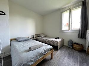 1 dormitorio con 2 camas individuales y ventana en Évasion Forestière : Confort et Moderne, en Samois-sur-Seine