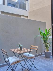 een tafel en twee stoelen en een tafel en een plant bij TheCasaEdition Gauthier Residency City Center in Casablanca