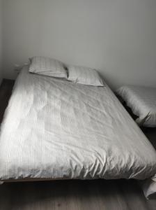 a bed with white sheets and pillows in a bedroom at 16 rue des Déportés in Charmes