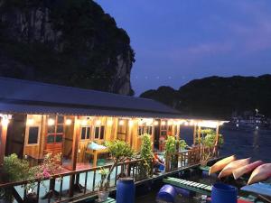 a restaurant on the water with boats in front of it at Eco Floating Farm Stay Cai Beo in Cat Ba