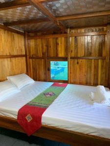 uma cama grande num quarto com uma janela em Eco Floating Farm Stay Cai Beo em Ilha de Cát Bà