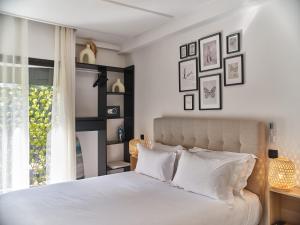 a bedroom with a bed with white pillows and a window at TheCasaEdition Gauthier Residency City Center in Casablanca