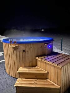 a hot tub with two glasses of wine at Villa Balos in Gronków