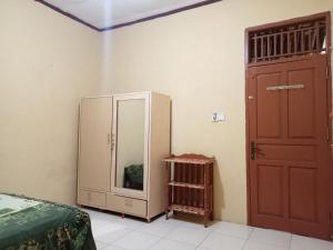 1 dormitorio con cama y espejo junto a una puerta en Penginapan Syari'ah Parak Anau, en Tabing