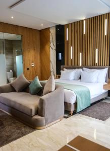 een slaapkamer met een groot bed en een bank bij Rim Aquatique Hôtel & Nature in Fès