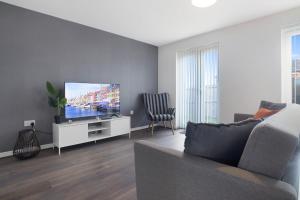 uma sala de estar com um sofá e uma televisão de ecrã plano em Charming 3 Bedroom House in Hartlepool, Sleeps 5 em Hartlepool