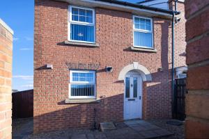 uma casa de tijolos com uma porta branca e janelas em Charming 3 Bedroom House in Hartlepool, Sleeps 5 em Hartlepool