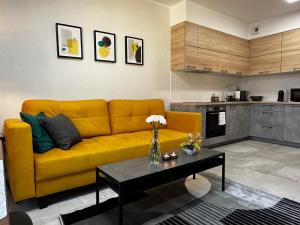 a living room with a yellow couch and a table at URBAN APARTMENTS PREMIUM, Opolska 10 No 80, Free Garage, Self Check-in in Katowice