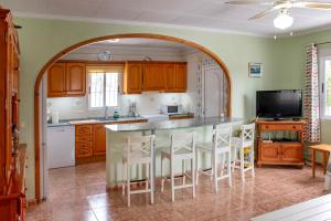 a kitchen with an archway over a kitchen island with stools at La Casa Del Sol in Torrevieja