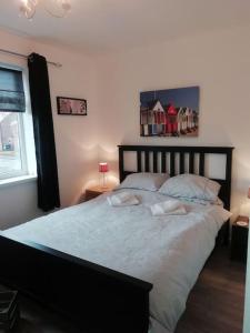 a bedroom with a large bed and a window at Beside the Seaside Tynemouth in Cullercoats