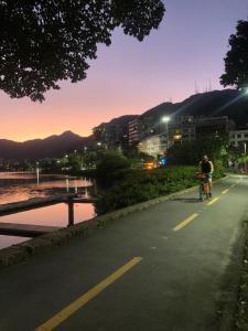 two people riding a bike down a road at night at Lagoa relax in Rio de Janeiro