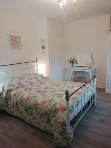 a bedroom with a bed with a floral comforter at Beside the Seaside Tynemouth in Cullercoats