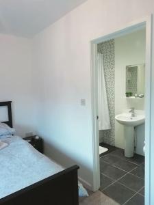 a bedroom with a bed and a bathroom with a sink at Beside the Seaside Tynemouth in Cullercoats
