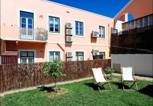 two chairs in a yard in front of a house at Oeiras 4 in Oeiras