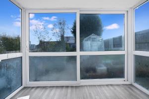 an empty room with three windows with a view at Spacious Living Room & Modern Comforts, Sleeps 4 in Peterlee