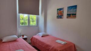 una camera da letto con due letti e una finestra di Lightoasis Oeiras 4 a Oeiras