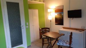 ein Wohnzimmer mit einem Tisch und einem TV in der Unterkunft Casa vacanze Il cancello rosso in Montefranco