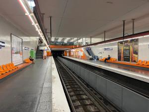 an empty subway station with orange seats in a building at Grand F3 Paris Stade de France & La Villette, 6 pers - Metro 7 in Aubervilliers