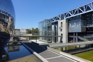 a view of a building with a bridge and some water at Grand F3 Paris Stade de France & La Villette, 6 pers - Metro 7 in Aubervilliers