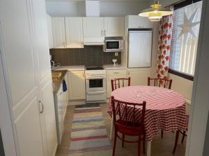 eine Küche mit einem Tisch und Stühlen sowie eine Küche mit weißen Schränken in der Unterkunft Row house in Meltosjärvi in Meltosjärvi