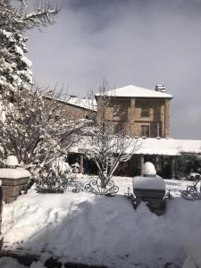 un patio cubierto de nieve con un edificio en el fondo en Vila Falo, en Voskopojë