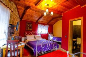 1 dormitorio con 2 camas y techo de madera en Vila Falo, en Voskopojë