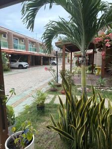 a courtyard with a palm tree and a building at Cantinho do aconchego de Arembepe in Camaçari