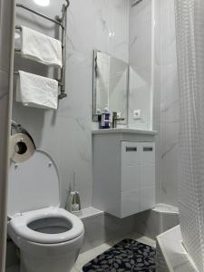 a white bathroom with a toilet and a mirror at мини-отель Villa Sofia город Шымкент, проспект Тауке хана, жилой дом 37-2 этаж in Shymkent