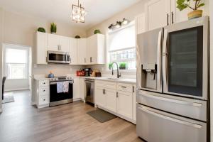 a kitchen with white cabinets and a stainless steel refrigerator at Updated Denver Home Near Parks, Dining and Shops! in Denver