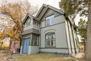 a gray house with a blue door on a street at Updated Denver Home Near Parks, Dining and Shops! in Denver