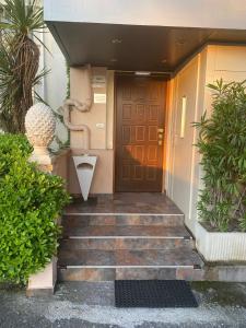 una porta d'ingresso di una casa con scale e piante di Residenza Segrate Centro Novegro a Segrate