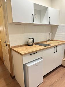 a kitchen with white cabinets and a sink at мини-отель Villa Sofia город Шымкент, проспект Тауке хана, жилой дом 37-2 этаж in Shymkent